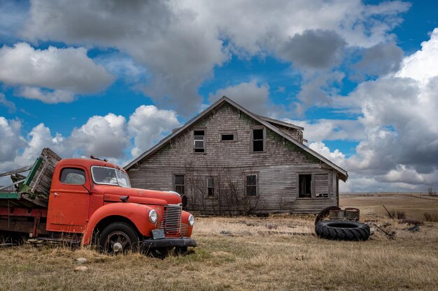 Ciel bleu au-dessus d'une vieille maison abandonnée et d'un camion dans les prairies de la Saskatchewan
