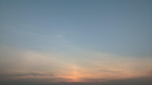 Un ciel bleu avec un coucher de soleil en arrière-plan