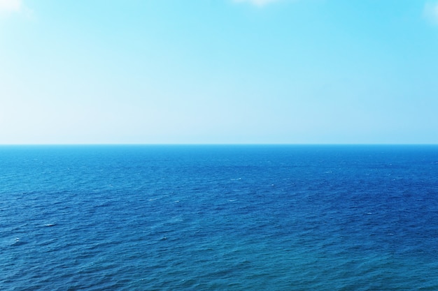 Photo ciel bleu sur la mer avec reflet. mer paisible de texture harmonieuse à l'eau.