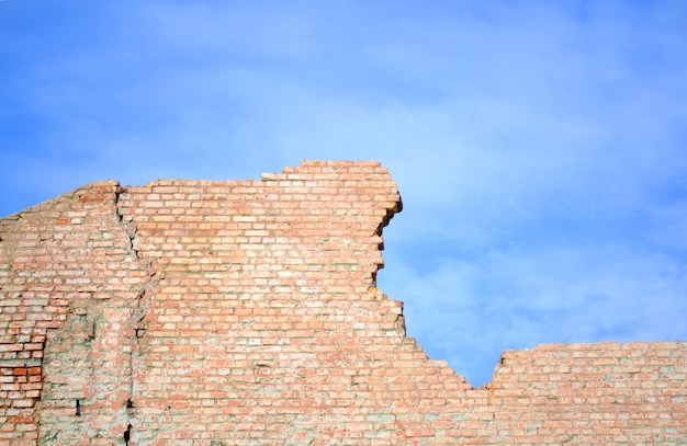 Photo ciel bleu et mur de briques mur de brique rouge brisé contre le ciel bleu