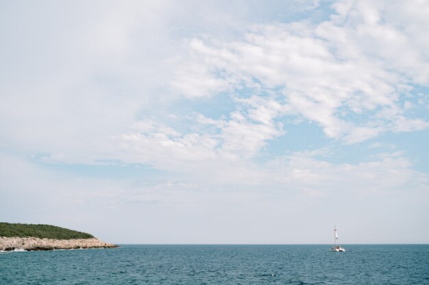 Ciel bleu avec des nuages blancs catamaran flotte sur la mer au loin