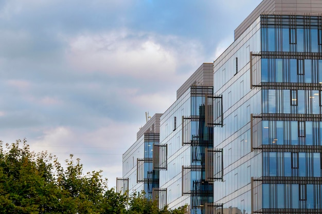 Le ciel bleu avec des nuages blancs se reflète dans les fenêtres d'un centre d'affaires moderne