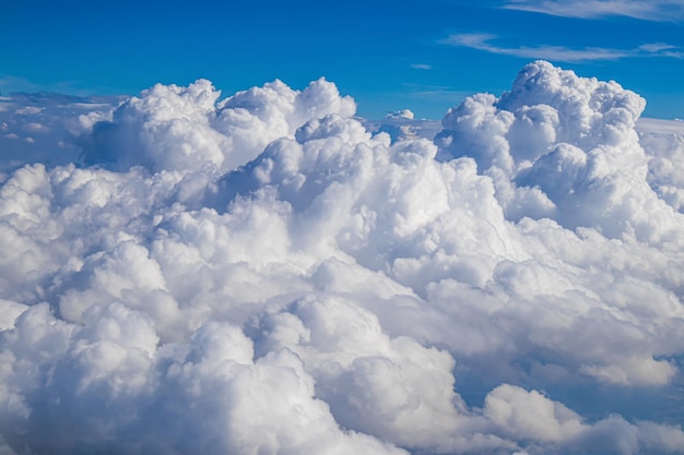 Ciel bleu avec des nuages blancs, vue aérienne d'en haut depuis un avion. Arrière-plan avec place pour le texte