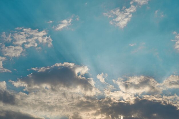 Ciel bleu avec nuages et rayons de soleil