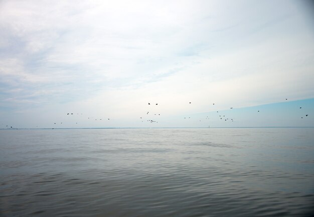 Ciel bleu avec nuages et reflet du soleil dans l'eau avec place pour votre texte. nuages anazing, brume dans le ciel