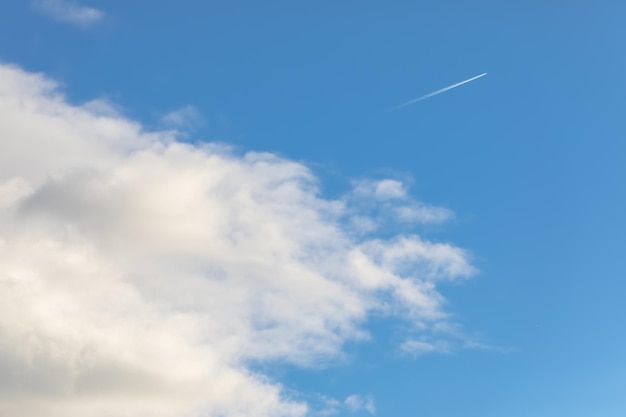 Ciel bleu avec nuages et sentier d'un avion volant haut