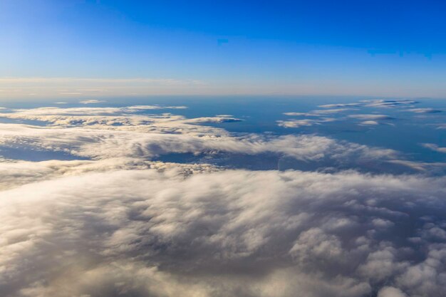 Ciel bleu et nuages vus à travers la fenêtre de l'avion