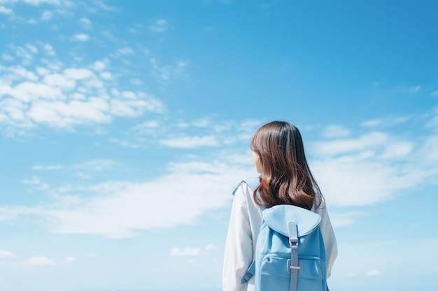 Le ciel bleu et la vue arrière de la fille