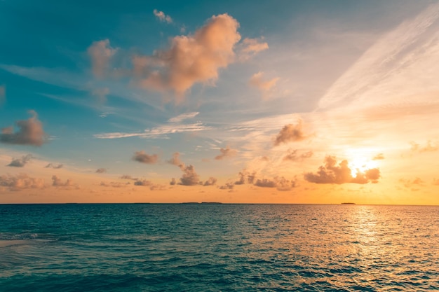 Ciel coucher de soleil coloré avec des nuages dorés au-dessus de la mer. Vagues de la mer inspirantes, horizon de la surface de l'eau