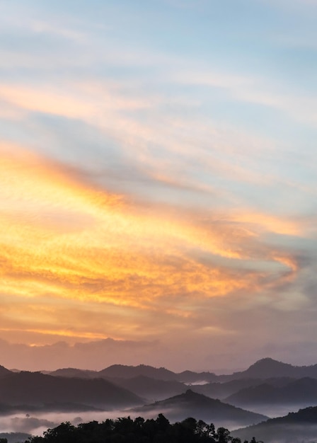 Ciel coucher de soleil vertical avec lever de soleil orange le matin et brouillard sur les montagnes