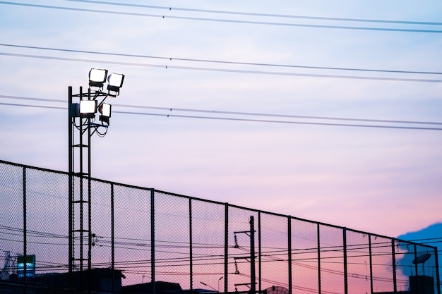 Ciel crépusculaire sur le terrain de football avec silhouette sportlight