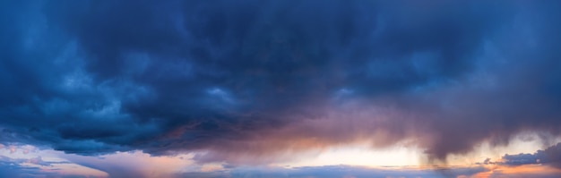 Ciel dramatique avec des nuages sombres et pluvieux au coucher du soleil.