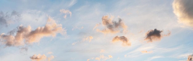 Ciel du soir avec quelques nuages jaunes oranges, blancs gris et sombres - large bannière