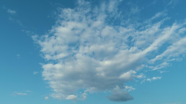 Le ciel est ensoleillé et venteux avec des tons bleus. Le nuage est un aérosol composé d'une masse visible de liquide.