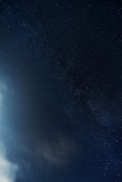 Ciel étoilé de nuit avec des nuages illuminés par le clair de lune. Paysage de nuit. Astrophotographie.