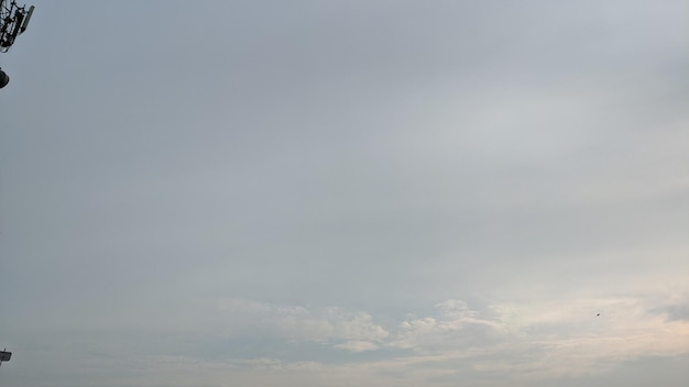 Un ciel gris avec un nuage blanc au milieu et un nuage blanc dans le ciel.