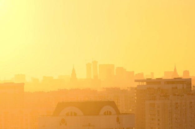 Photo un ciel jaune est au-dessus d'une ville et le soleil se couche.