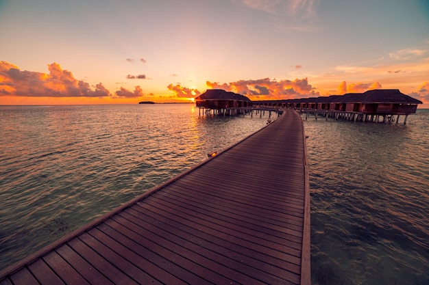 Ciel de mer au coucher du soleil de l'île des Maldives. Bungalows sur pilotis plage des îles de villégiature. Océan Indien. Belles villas