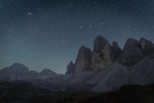 Photo ciel nocturne au-dessus d'une formation rocheuse massive tre cime montagnes dolomites italie