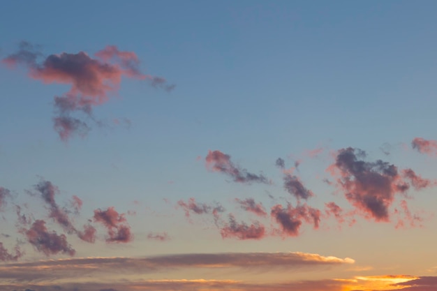 Le ciel et les nuages au fond du coucher du soleil