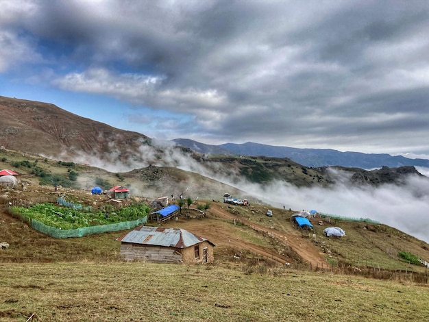 Un ciel nuageux au-dessus des montagnes avec un village natal.