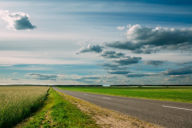 Ciel nuageux sur les champs verdoyants et l'autoroute