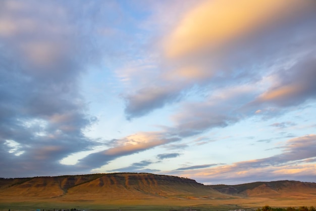 Ciel pittoresque avec des nuages Le coucher du soleil illumine la chaîne de montagnes