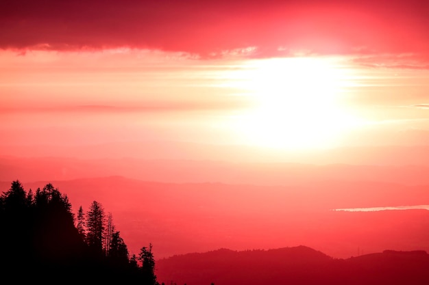 Ciel rouge au coucher du soleil sur les silhouettes des collines