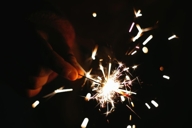 Cierge magique festif avec des étincelles dans les mains