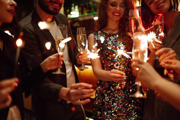 Des cierges étincelants dans les mains Jouer un feu d'artifice pour célébrer les vacances d'hiver Magic New Year