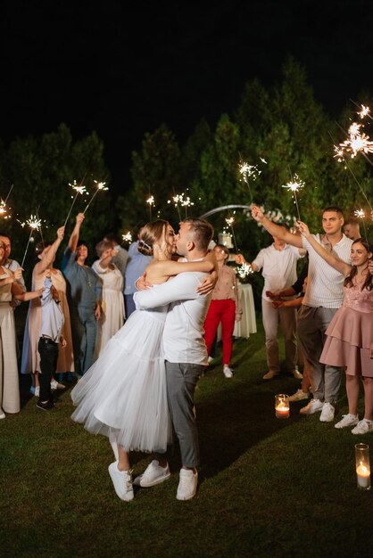 Des cierges magiques au mariage des jeunes mariés entre les mains d'invités joyeux