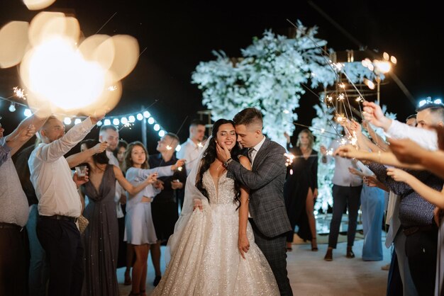 Des cierges magiques au mariage des jeunes mariés entre les mains d'invités joyeux