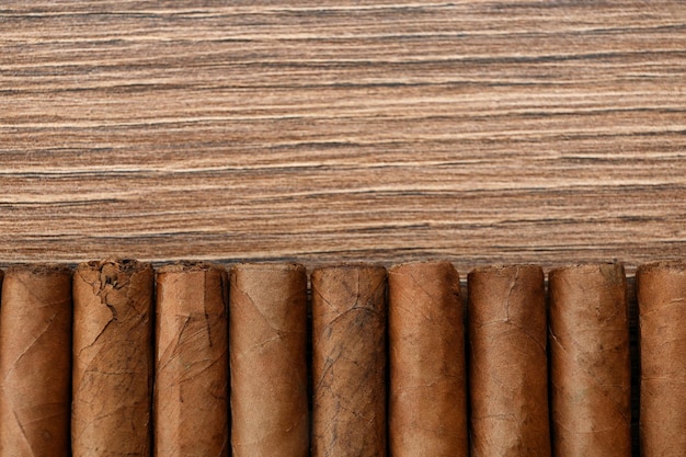 Cigares enveloppés dans des feuilles de tabac sur une table en bois mise à plat Espace pour le texte