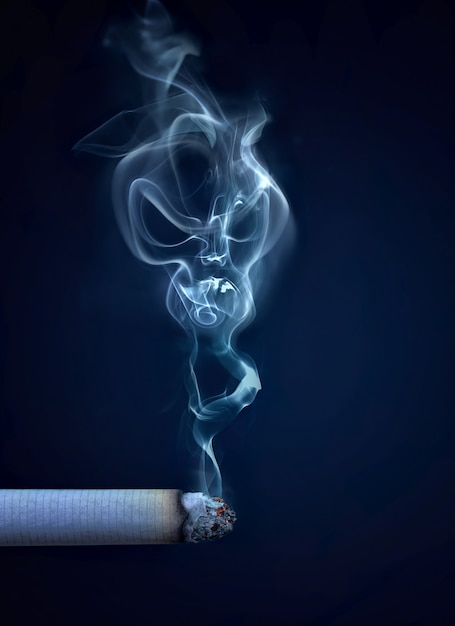 Cigarette allumée avec de la fumée en forme de crâne image conceptuelle