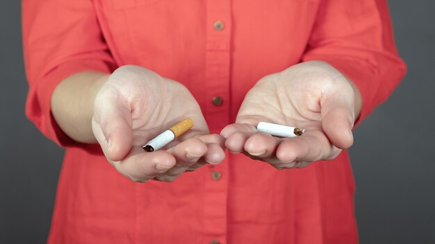 cigarette cassée dans les mains des femmes, arrêtez de fumer.