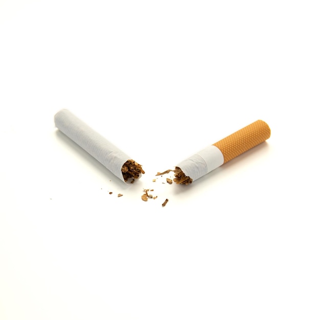 Cigarette cassée en deux avec filtre orange isolé sur fond blanc