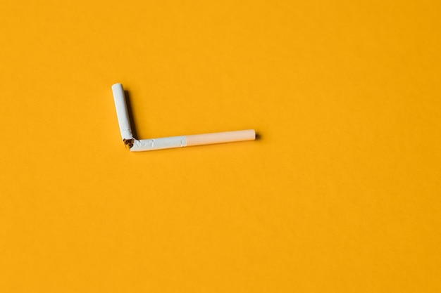 Cigarette cassée sur fond jaune Concept non fumeur