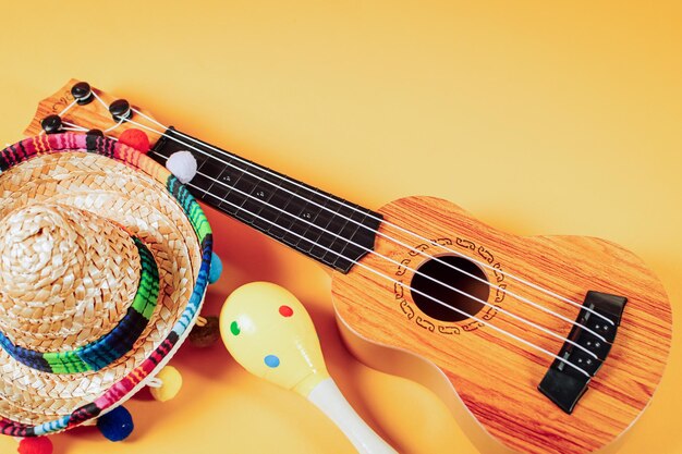 Photo cinco de mayo fond de fête maracas chapeau mexicain et guitare sur fond orange