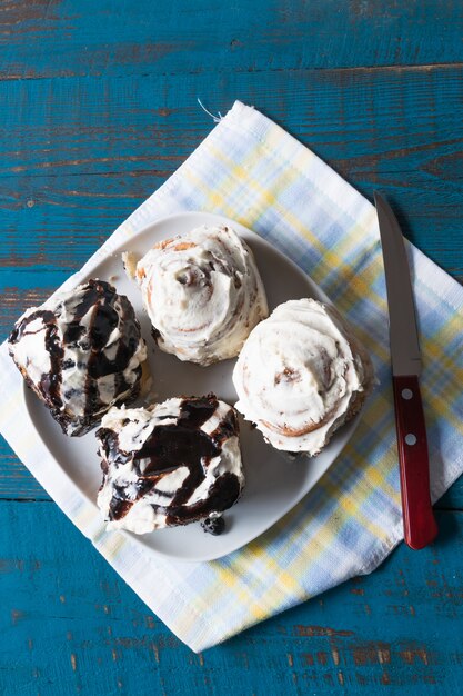 Cinnabon - Rouleau de cannelle avec fromage à la crème et chocolat, sur une assiette, sur une serviette.