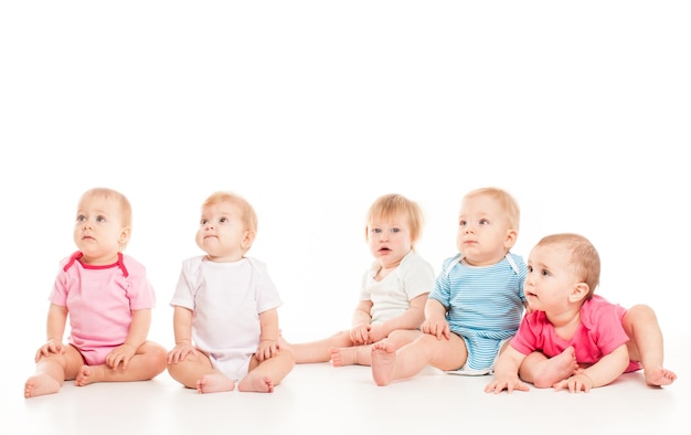 Cinq bébés isolés isolés sur fond blanc