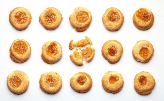 Cinq biscuits faits à la main avec de la confiture d'abricots disposés en rangées égales.