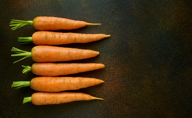 Cinq carottes sur noir, vue de dessus