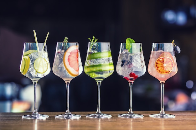 Photo cinq cocktails gin tonic colorés dans des verres à vin sur un comptoir de bar en pup ou au restaurant.