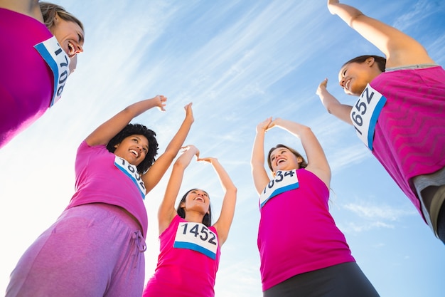 Cinq coureurs encourageant le marathon du cancer du sein