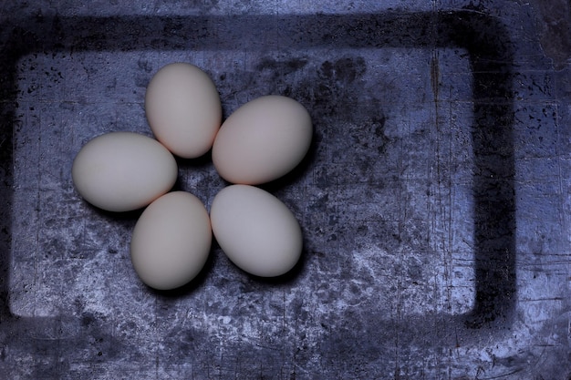 Cinq oeufs sous la forme d'une fleur sur un fond sombre des aliments sains biologiques Libre Vue d'en haut