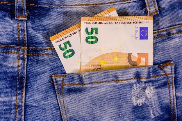 Cinquante billets en euros dans la poche du jean bleu