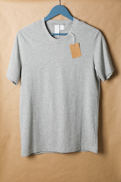 Cintre avec t-shirt gris vierge et étiquette sur carton