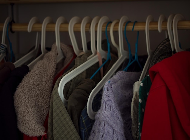 Cintres avec différents vêtements dans la garde-robe de la maison