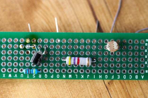 Circuit imprimé avec éléments électriques, sur une table en bois.