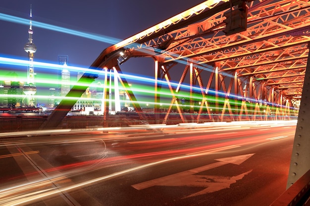 Circulation nocturne sur le pont de jardin de shanghai avec des sentiers de lumière